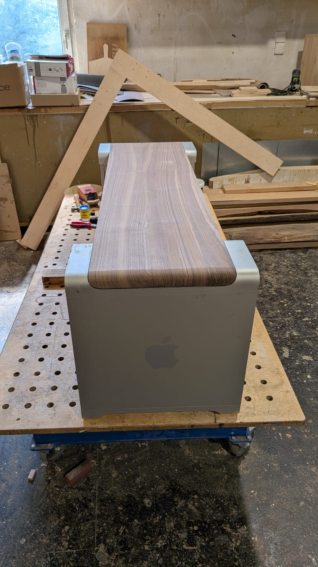 Side view of the Bench.1186 showing the walnut top curving over the edge of an aluminium Mac Pro enclosure.